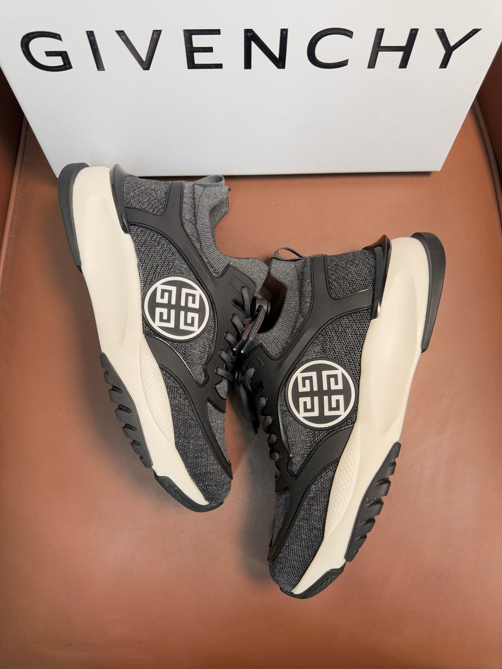 Dark gray lace-up sneakers, front angle, circular logo on side, white soles