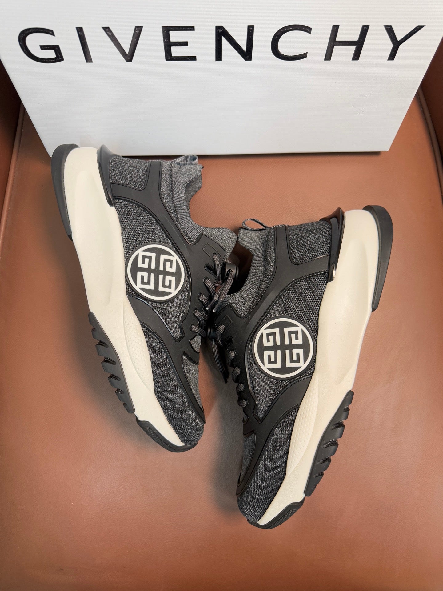 Dark gray lace-up sneakers, front angle, circular logo on side, white soles