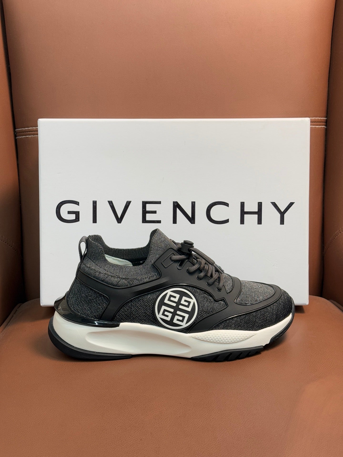 Dark gray lace-up sneakers with front logo emblem and white sole