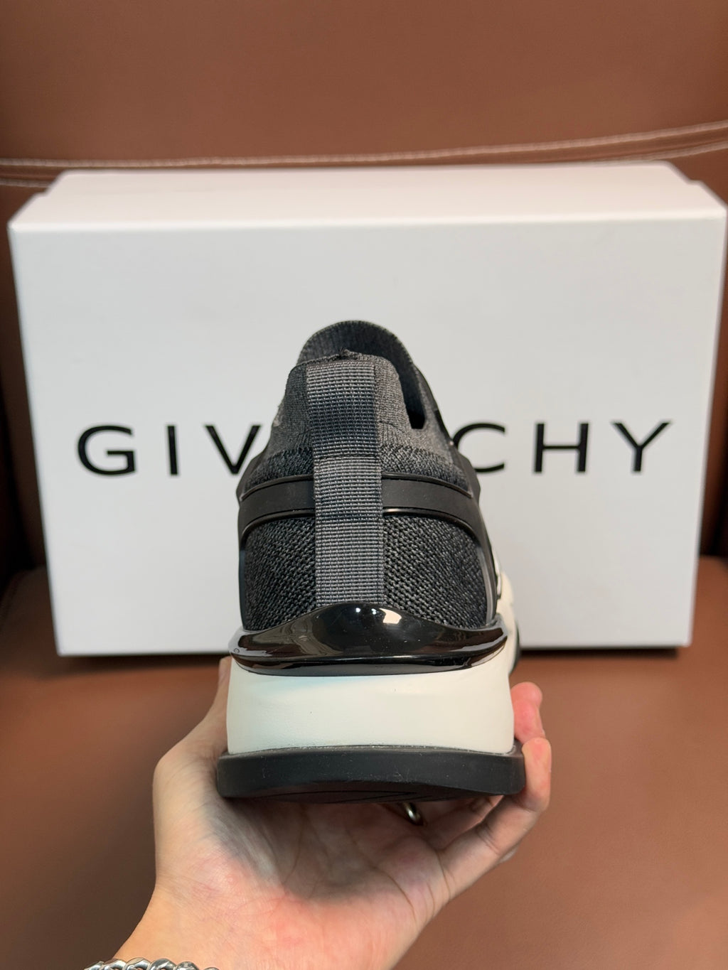 Dark gray lace-up sneakers, heel view, glossy accent on back, white sole