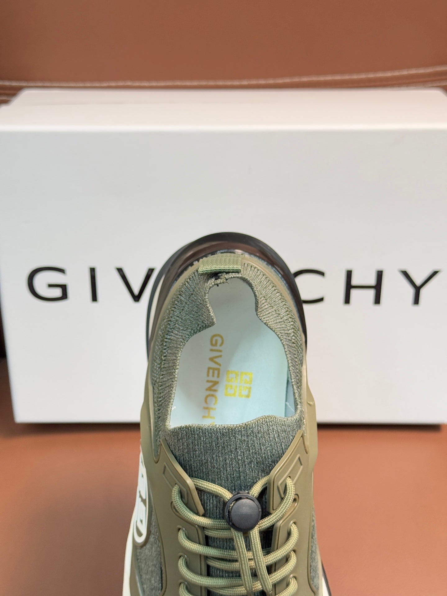 Givenchy sneaker toe view with olive knit upper and lace-up eyelets
