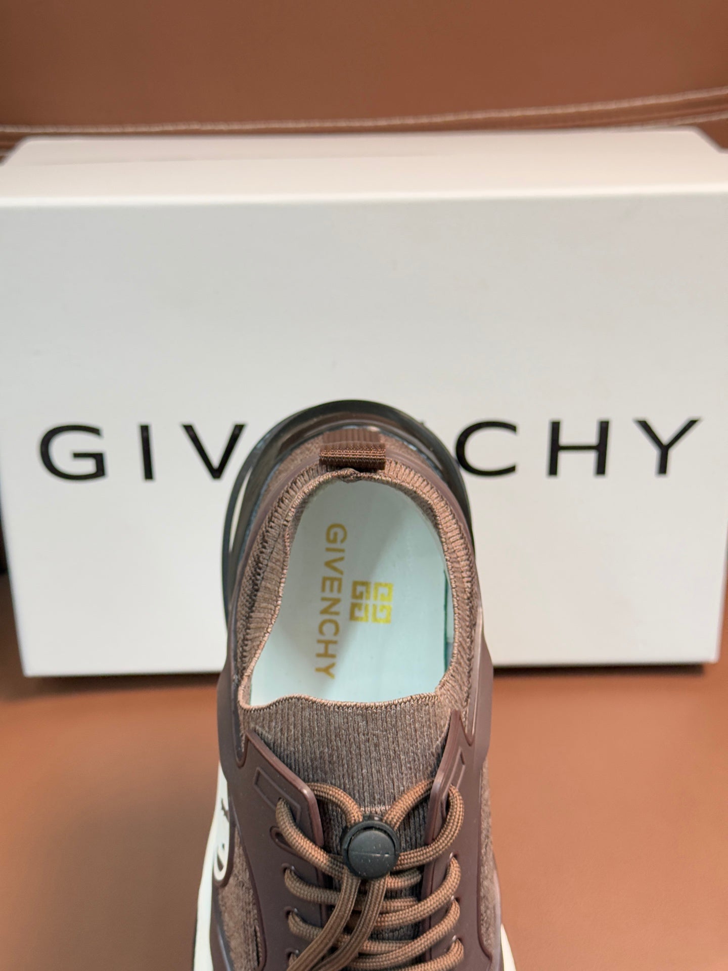 Brown Givenchy sneaker close-up of lace-up tongue and logo lining