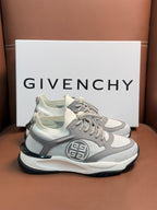 Light gray chunky sneakers with dark trim, lace closure, and front logo emblem.