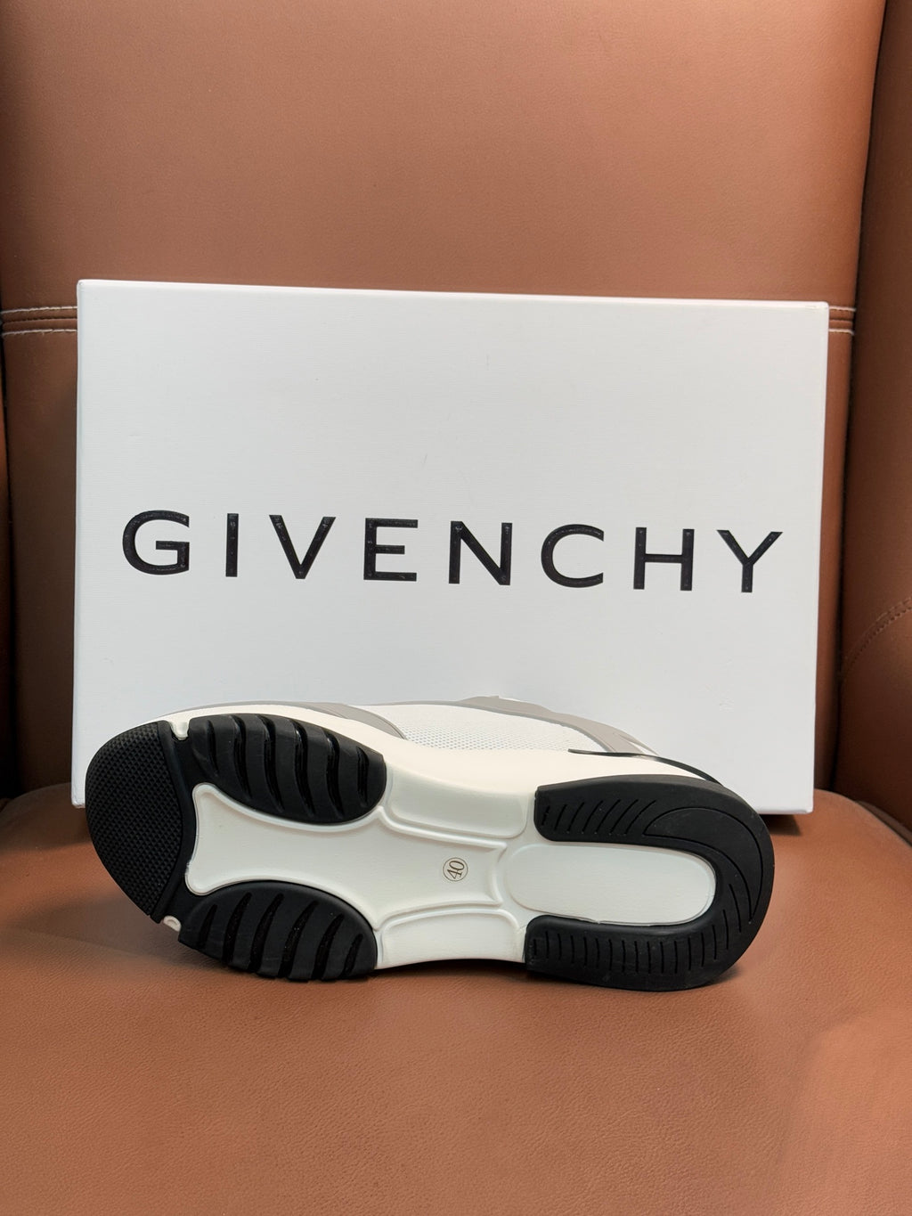 White and dark rubber sneaker outsole with tread pattern.