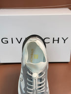 Light gray sneaker with textured upper, laces, and embroidered logo on tongue.