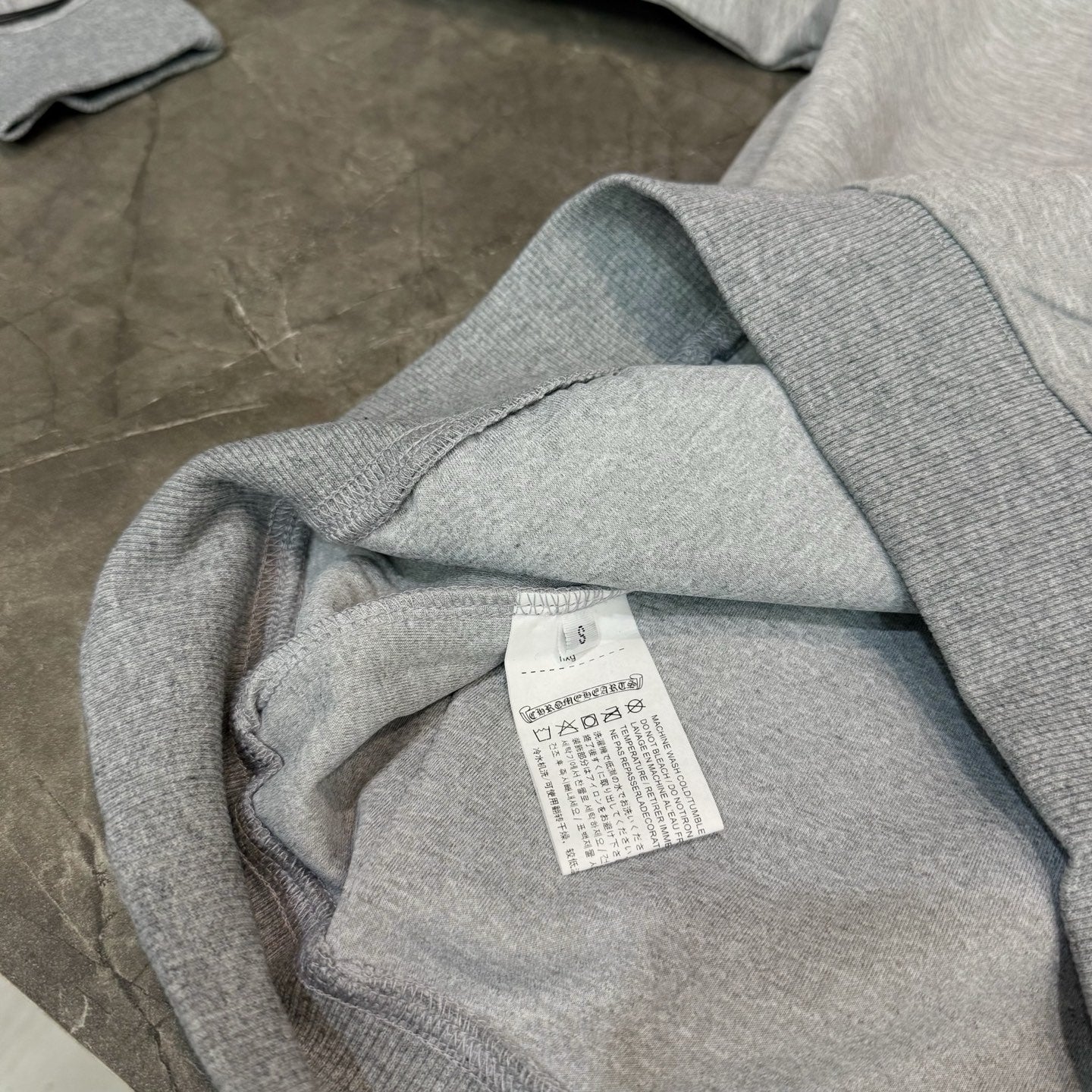 Grey hoodie inside label tag with ribbed cuff visible