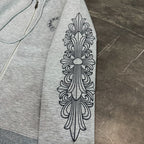 Grey hoodie sleeve with ornate leaf-like emblem graphic print