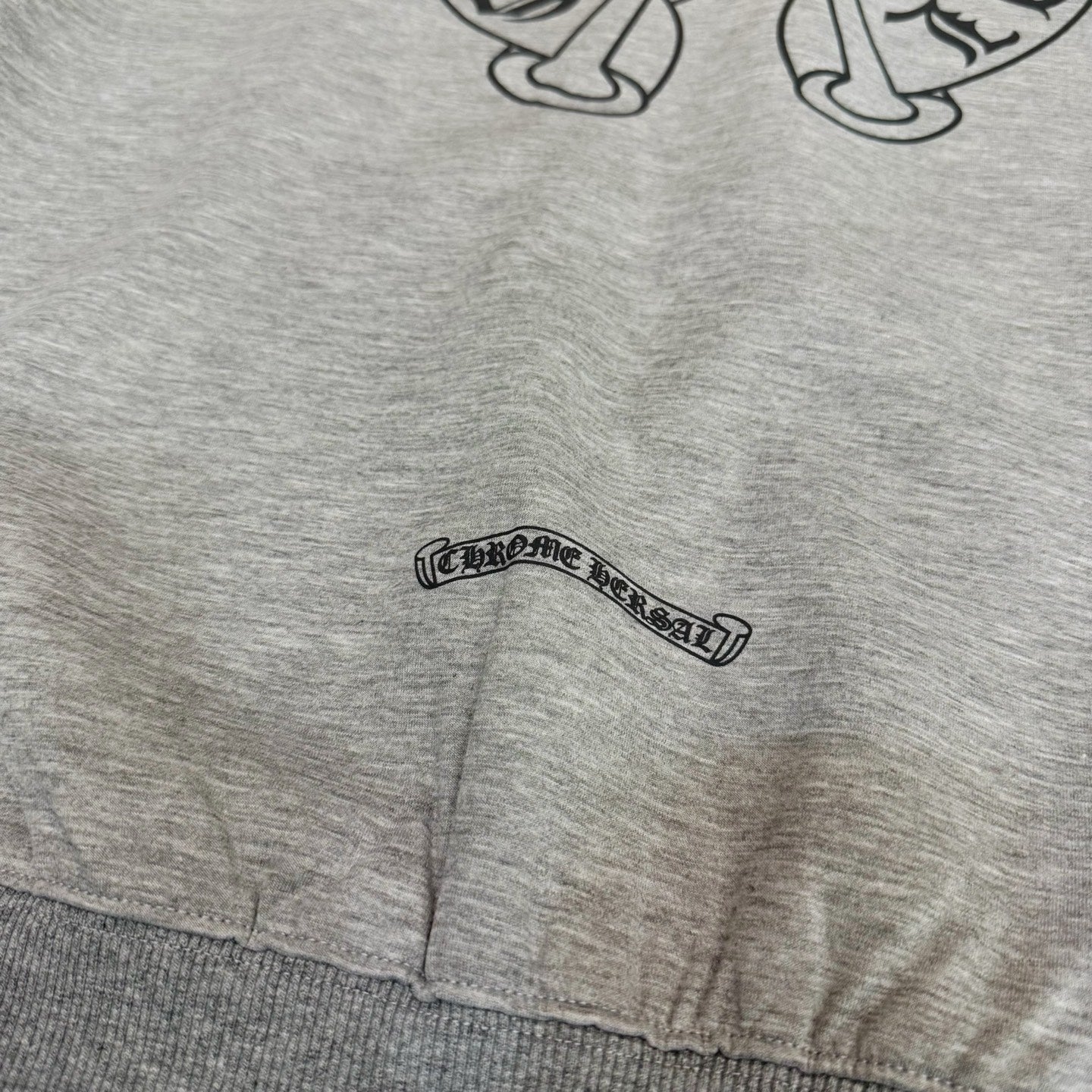 Grey hoodie hem with small logo patch