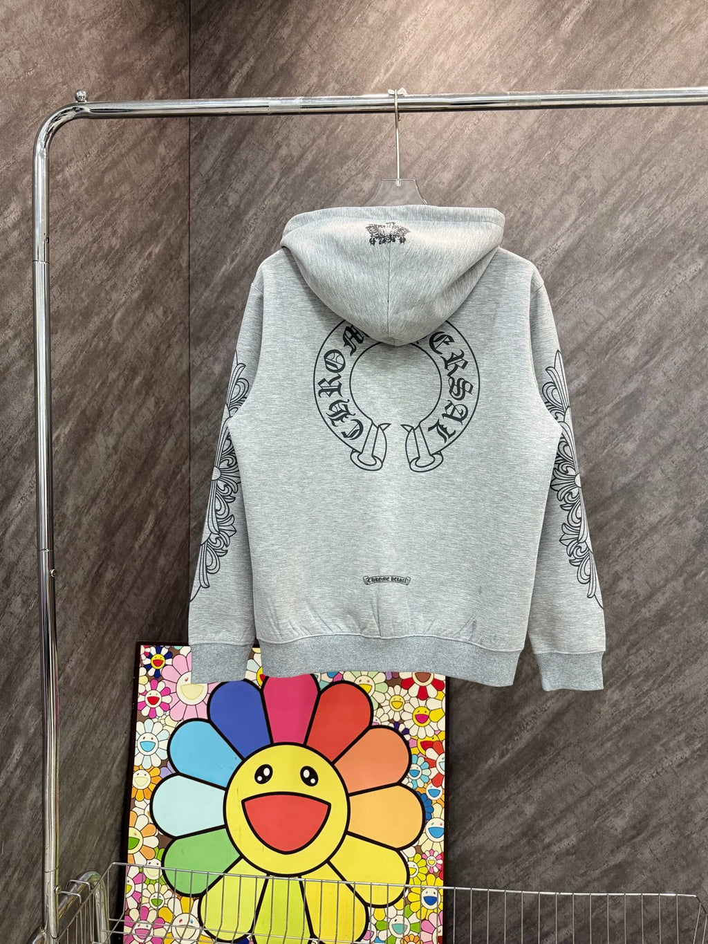 Grey zip-up hoodie with hood and circular graphic on chest, long sleeves