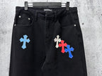Black denim pants with blue and red cross patches on the front