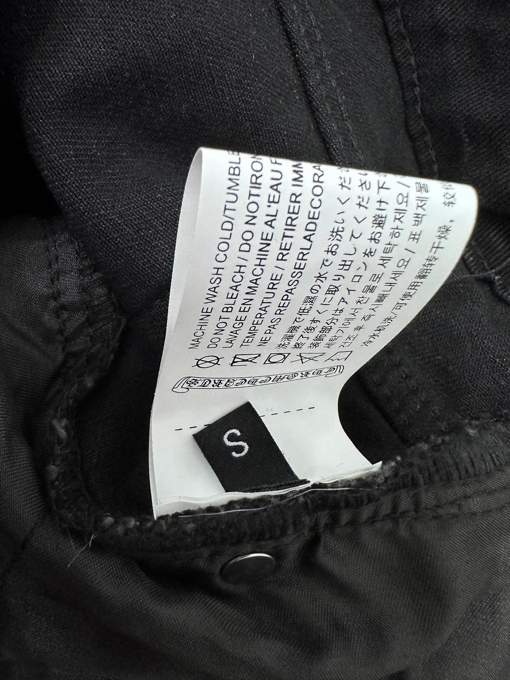 Black denim pants with size S care label stitched inside waistband