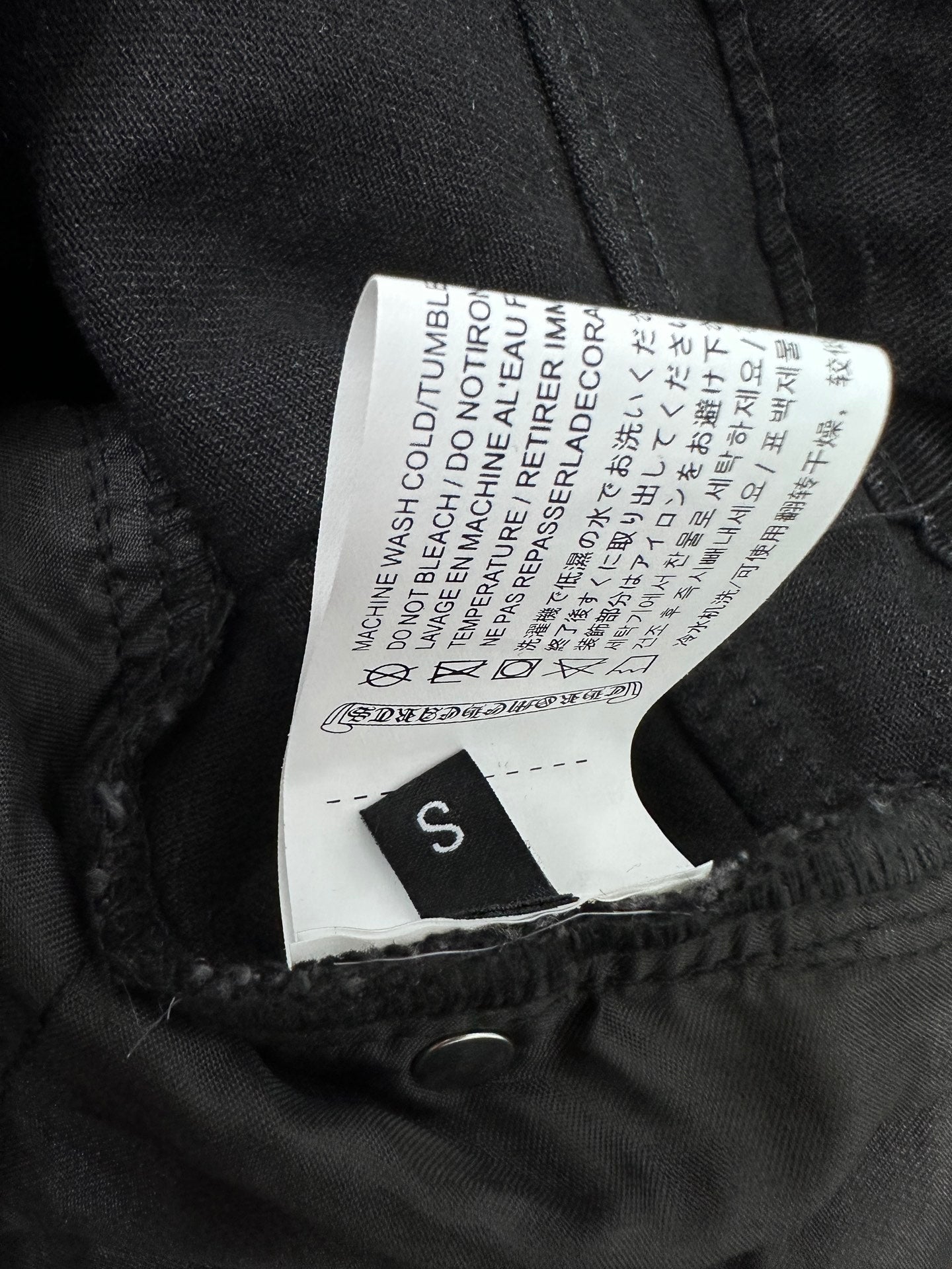 Black denim pants with size S care label stitched inside waistband