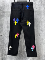 Black denim pants with scattered colorful cross patches, front and back view