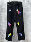 Black denim pants with colorful cross patches, front pockets and straight leg