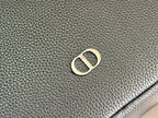 Dior men’s bag leather close-up with gold-tone D logo emblem
