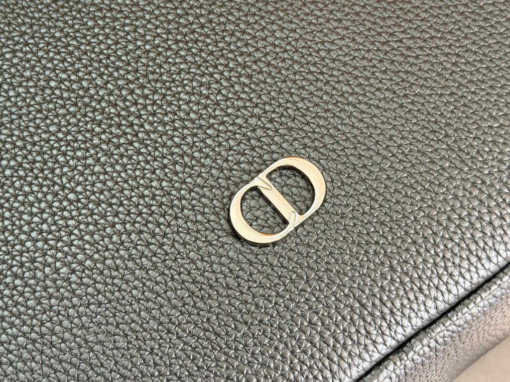 Close-up of textured dark leather with D-shaped logo hardware