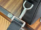 Dior men’s bag metal clasp and strap detail with Dior tag, dark leather