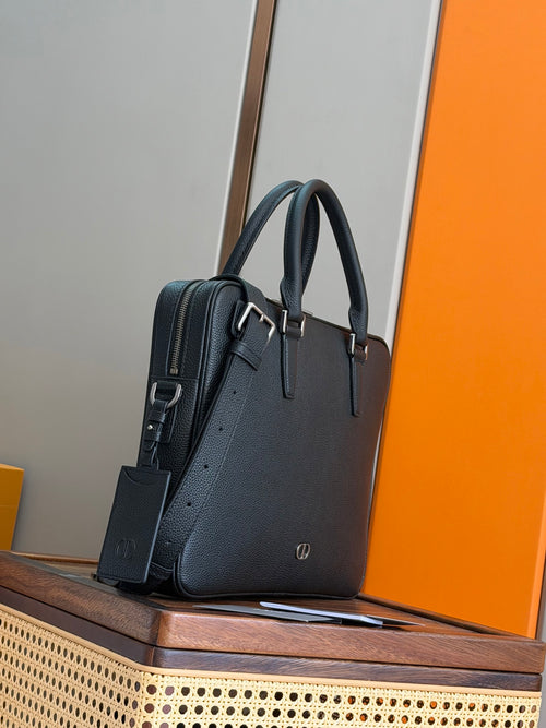 Dior men’s leather bag angled view with dual handles and side strap, dark