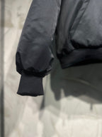 Long hooded jacket sleeve close-up, dark gray puffed shoulder and rib cuff