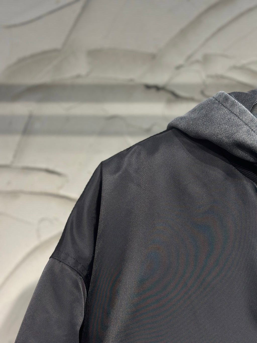 Long hooded jacket back close-up with dark gray fabric and hood seam
