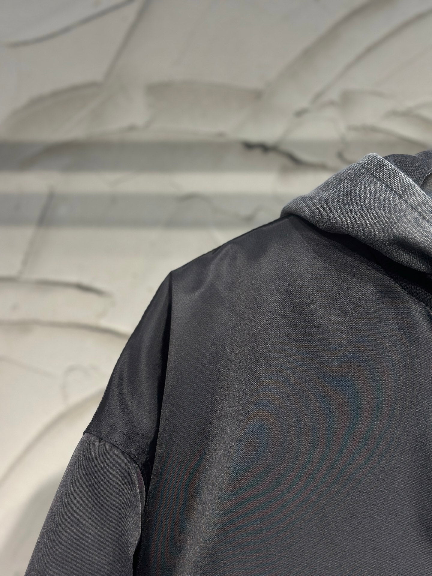 Long hooded jacket back close-up with dark gray fabric and hood seam