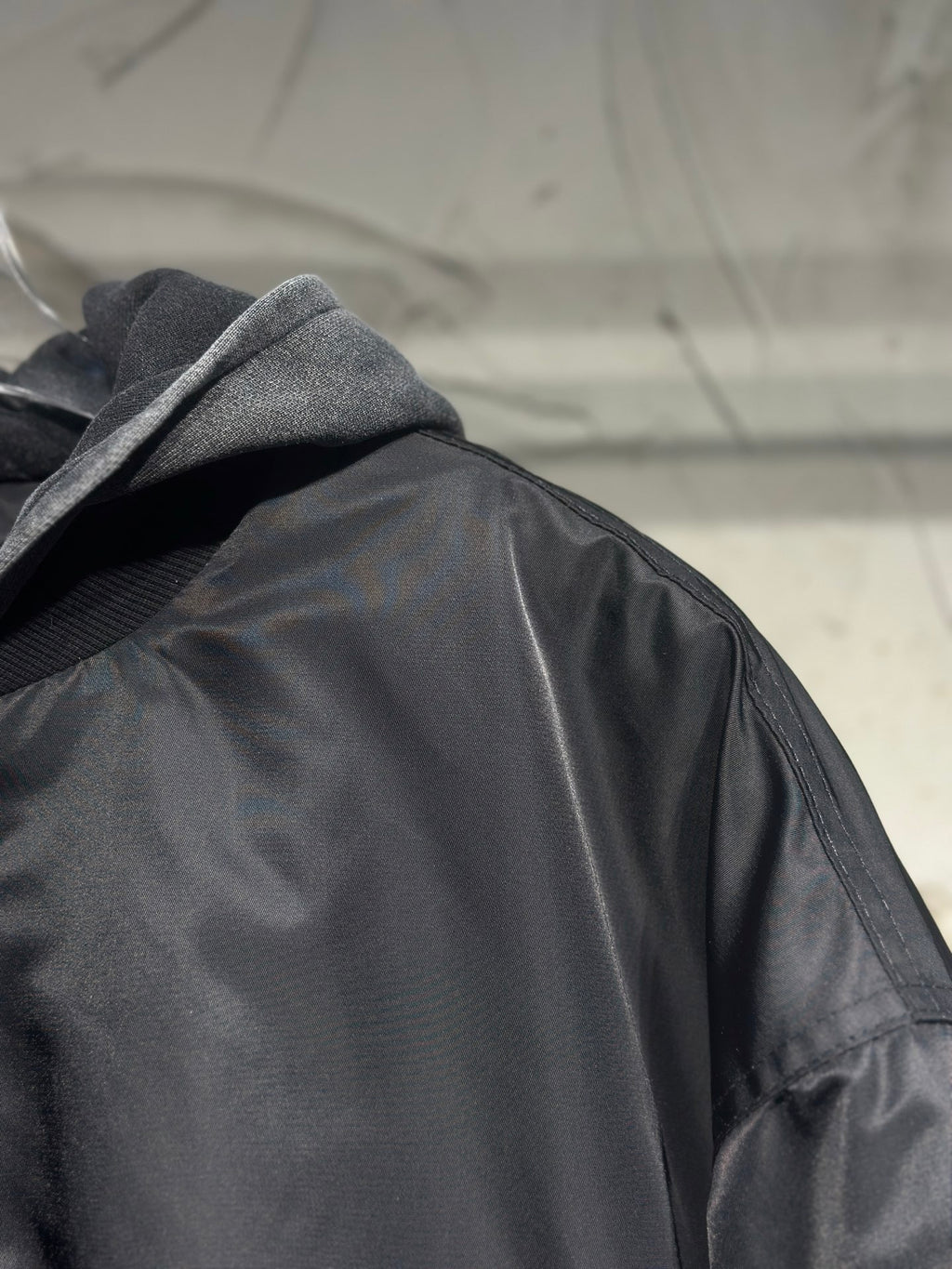Long hooded jacket close-up, dark gray satin fabric and hood lining