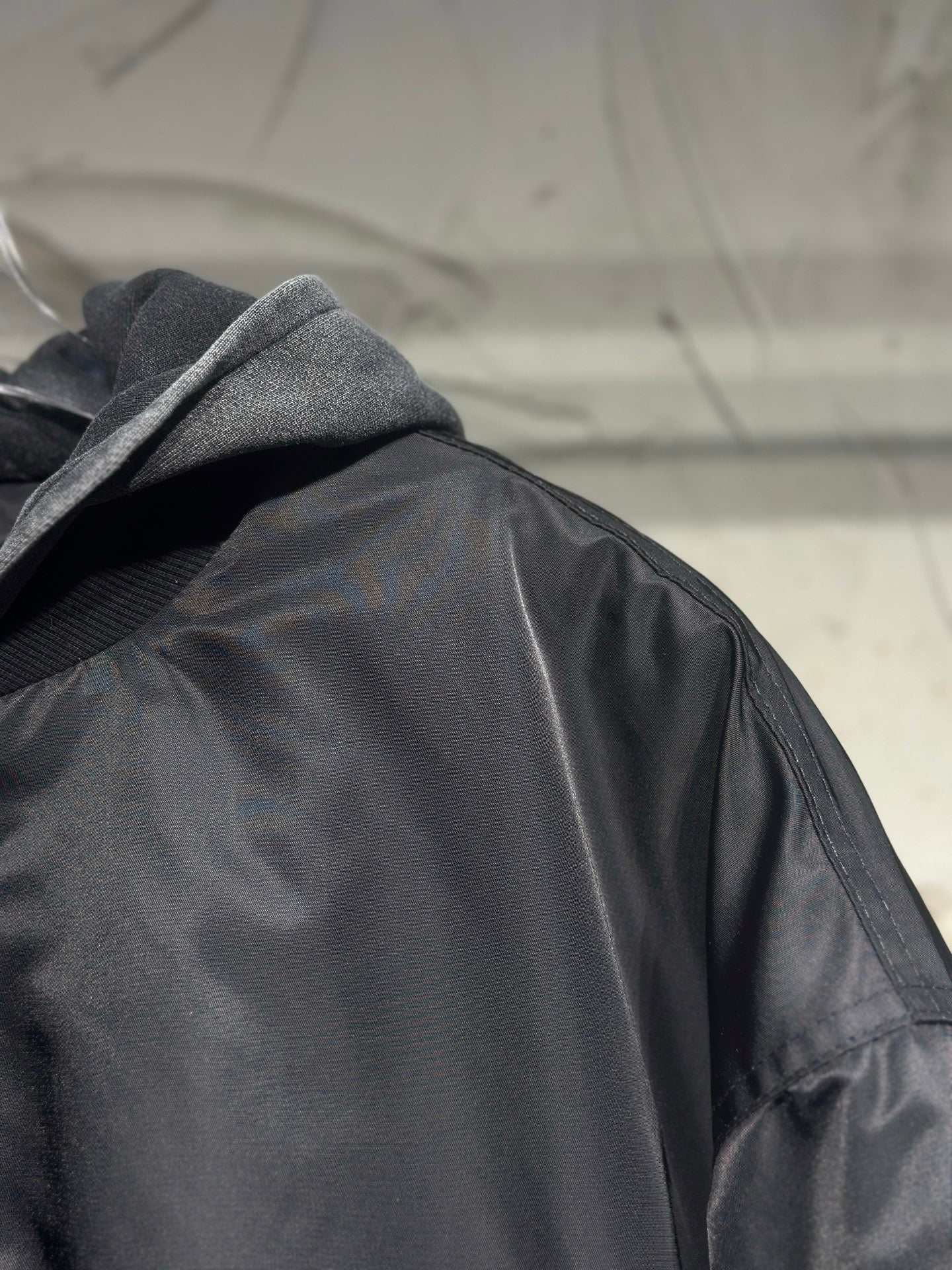 Long hooded jacket close-up, dark gray satin fabric and hood lining