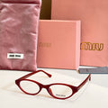 Miu Miu eyeglasses with dark red acetate frames and round clear lenses