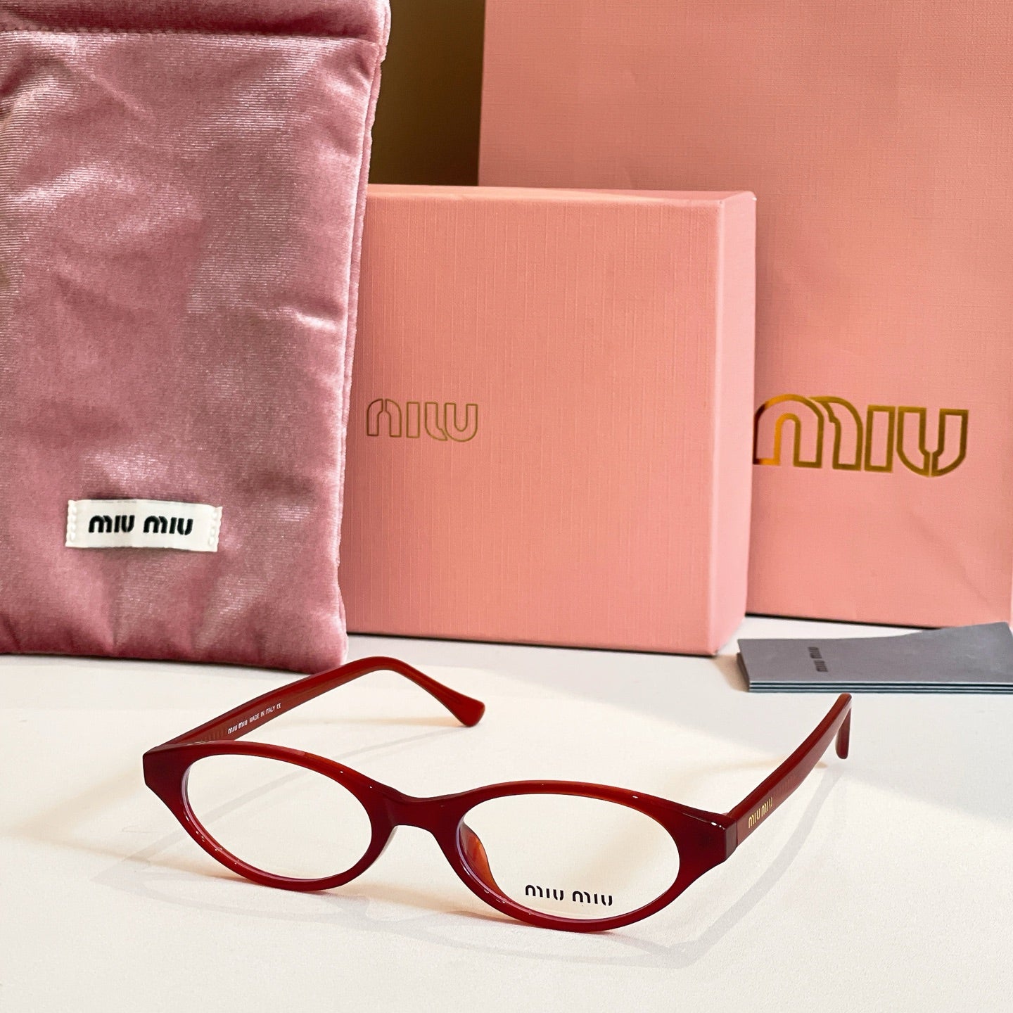 Miu Miu eyeglasses with dark red acetate frames and round clear lenses