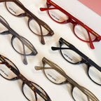 Assorted Miu Miu eyeglasses with dark, red, and tortoise frames arranged together