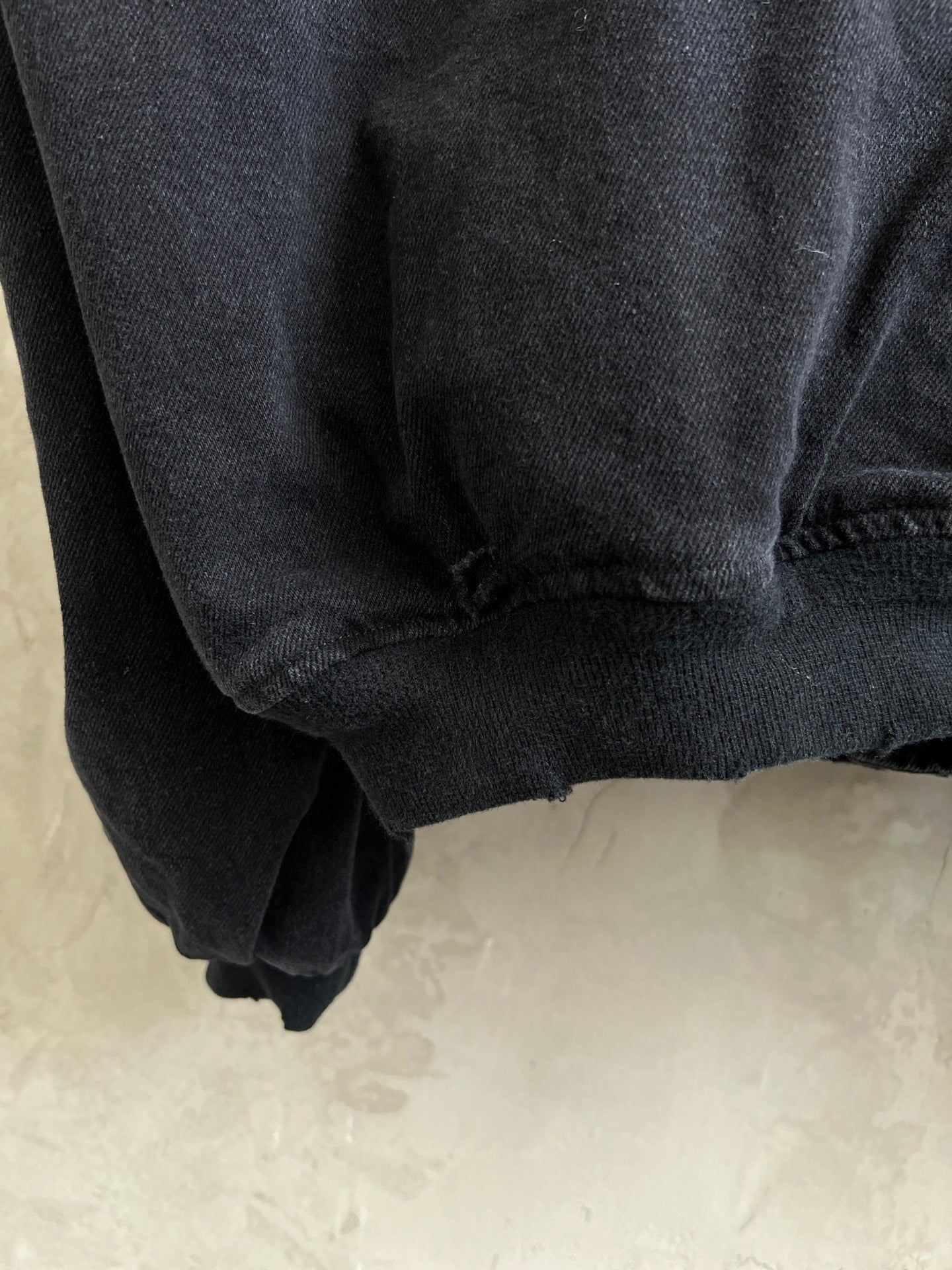 Dark zip-up jacket sleeve cuff and gathered hem