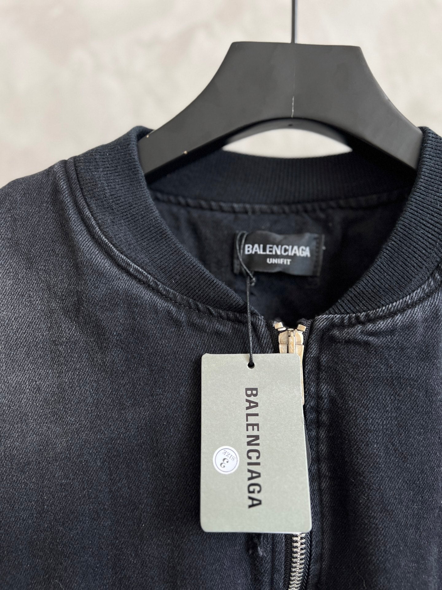 Balenciaga denim bomber jacket neckline with zipper and brand logo patch
