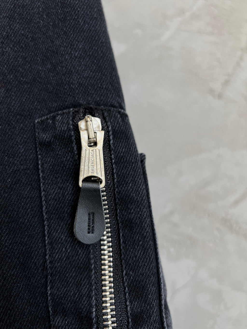 Balenciaga denim jacket sleeve with silver zipper pull and stitched pocket