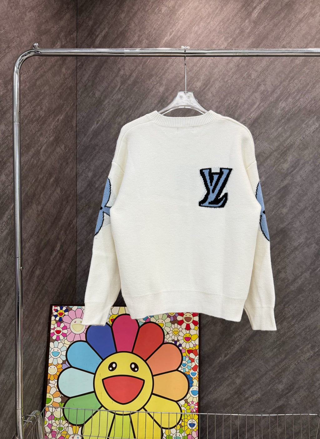 White long-sleeve knit sweatshirt with blue LV-style emblem on back and graphic sleeves