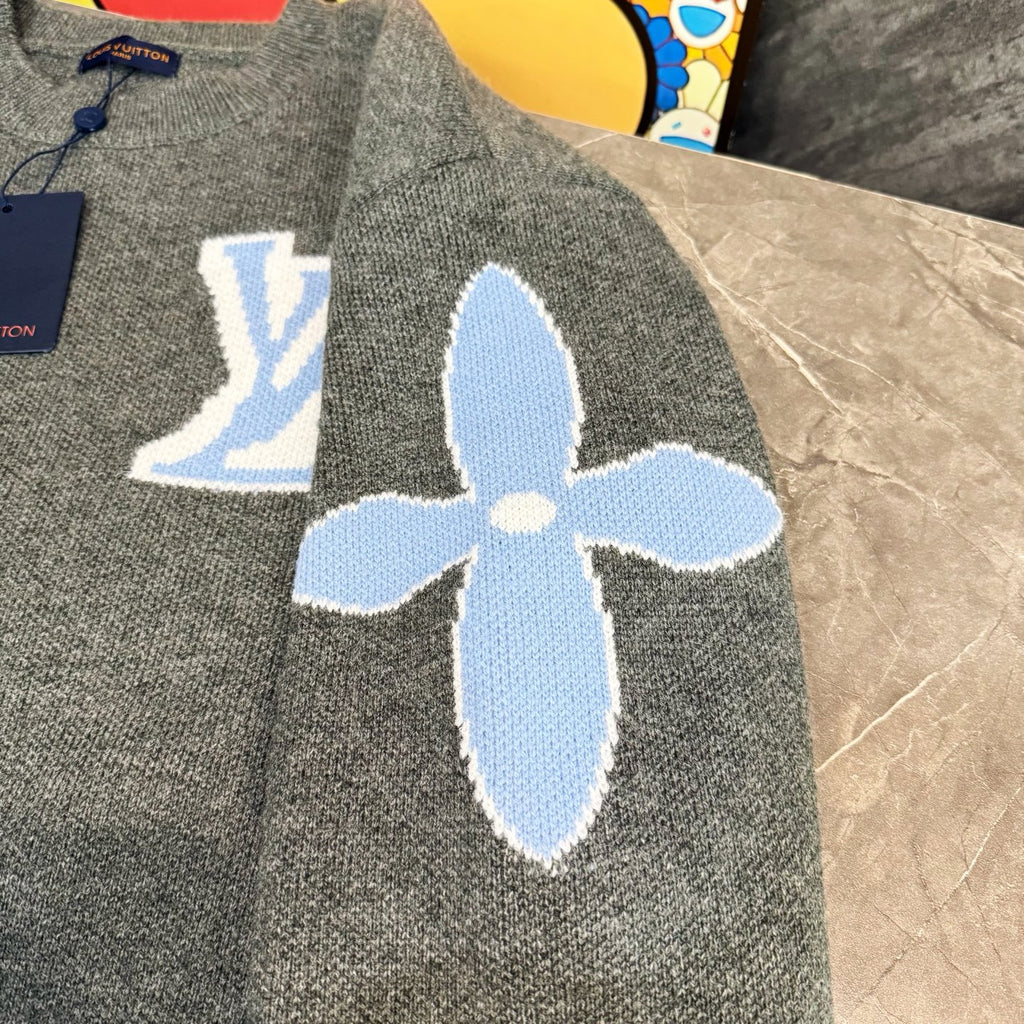 Gray knit long-sleeve sweater with large blue flower-like graphic and LV emblem background