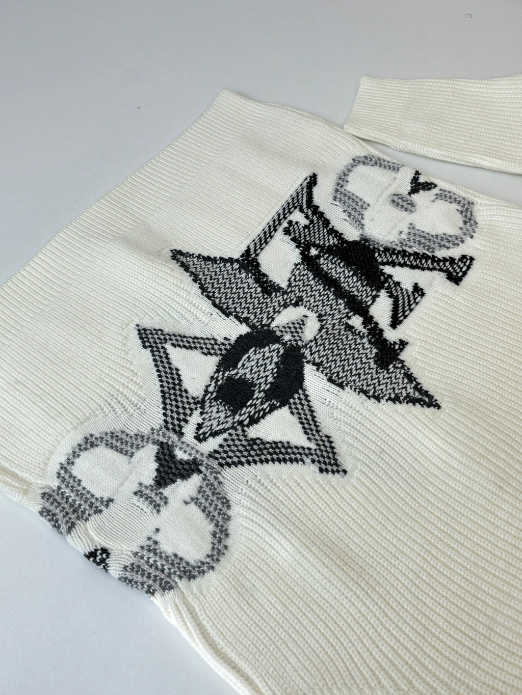 Ivory knit cardigan sleeve with black and gray graphic embroidery