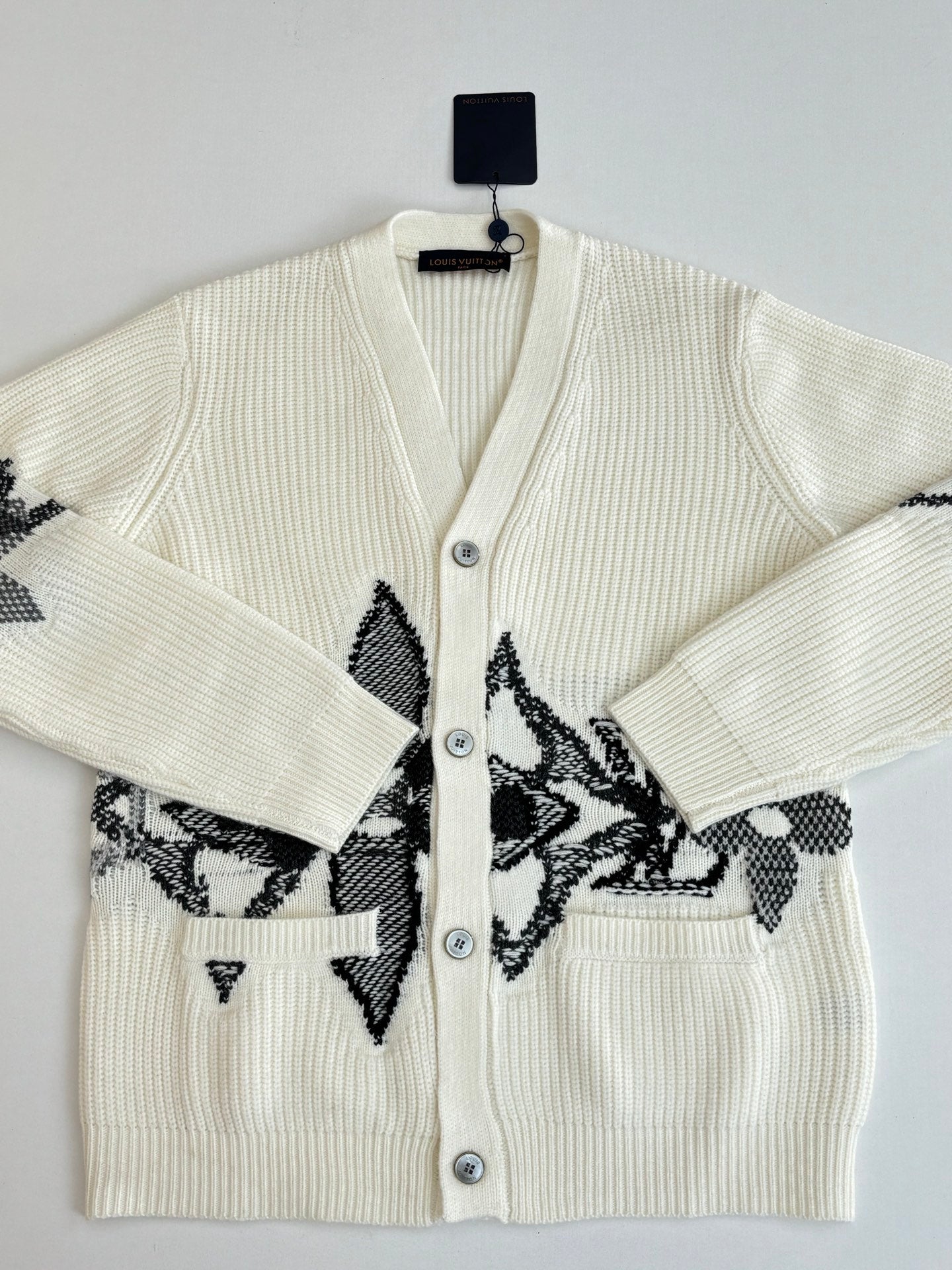 Ivory knit cardigan with black geometric motif and front button placket