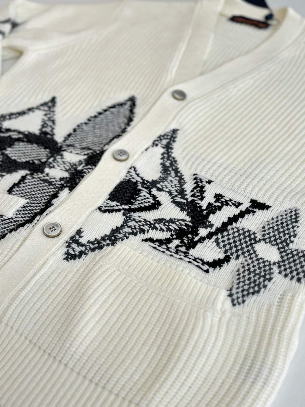 Ivory knit cardigan with black embroidered geometric motif and buttons