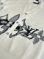 Ivory knit cardigan with black embroidered geometric motif and buttons