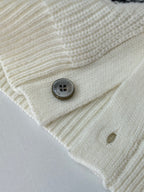 Ivory knit cardigan fabric close-up with round gray buttons