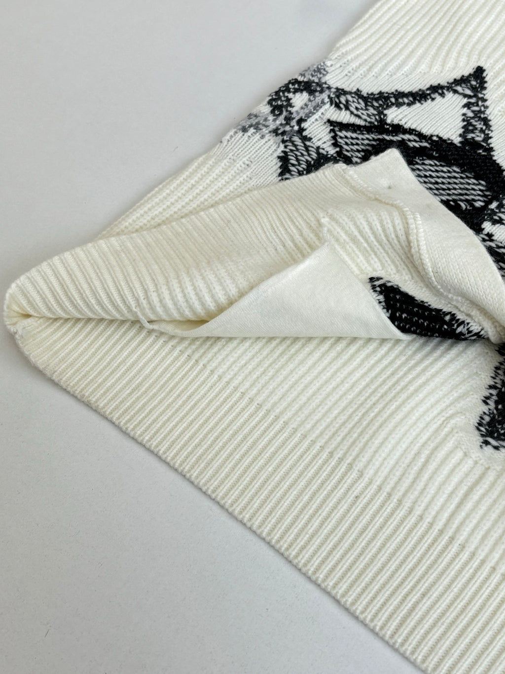 Ivory knit cardigan cuff and sleeve with black graphic print