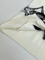 Ivory knit cardigan cuff and sleeve with black graphic print