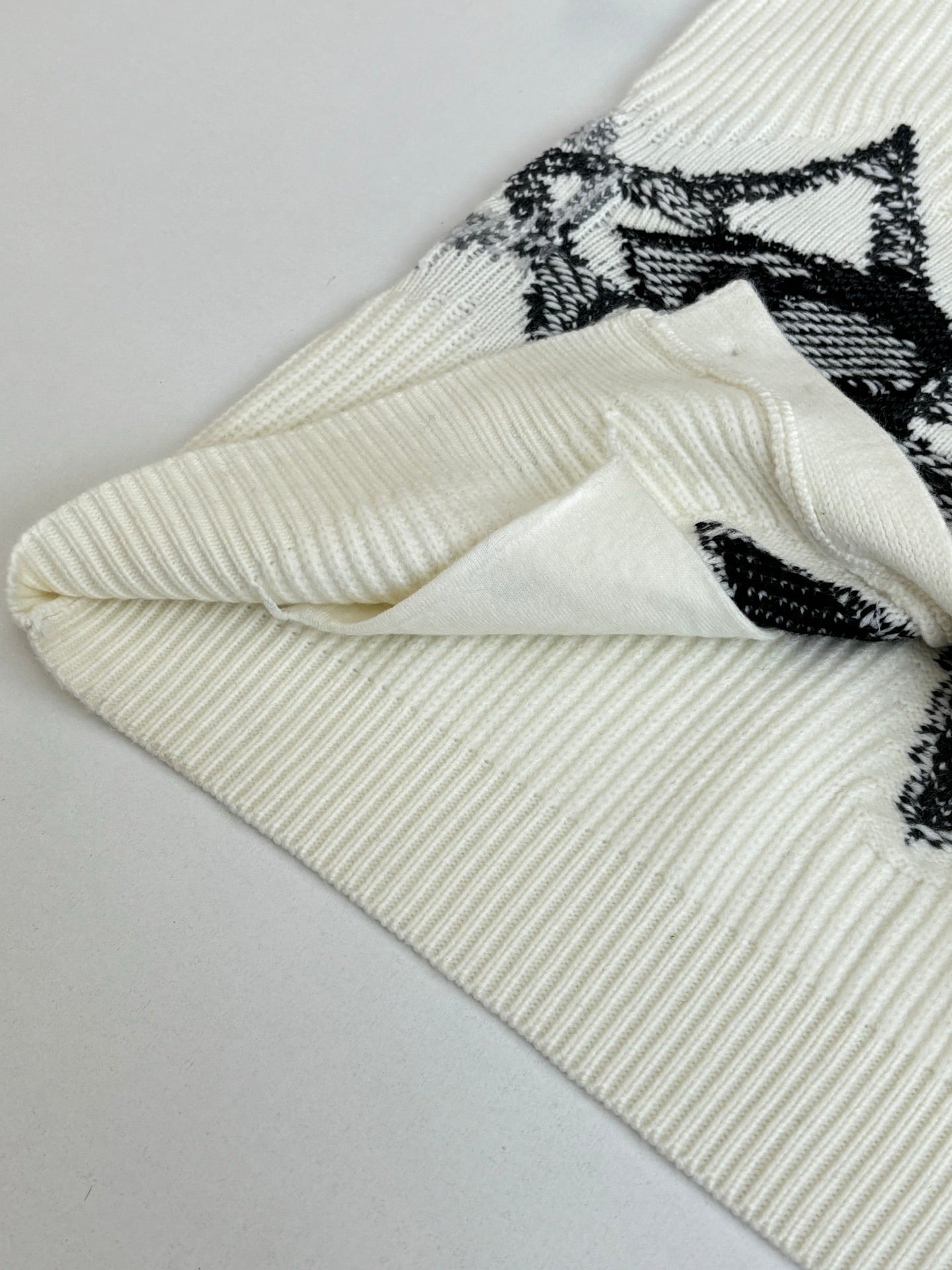Ivory knit cardigan cuff and sleeve with black graphic print