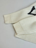Ivory knit cardigan sleeve and hem detail with black graphic motif