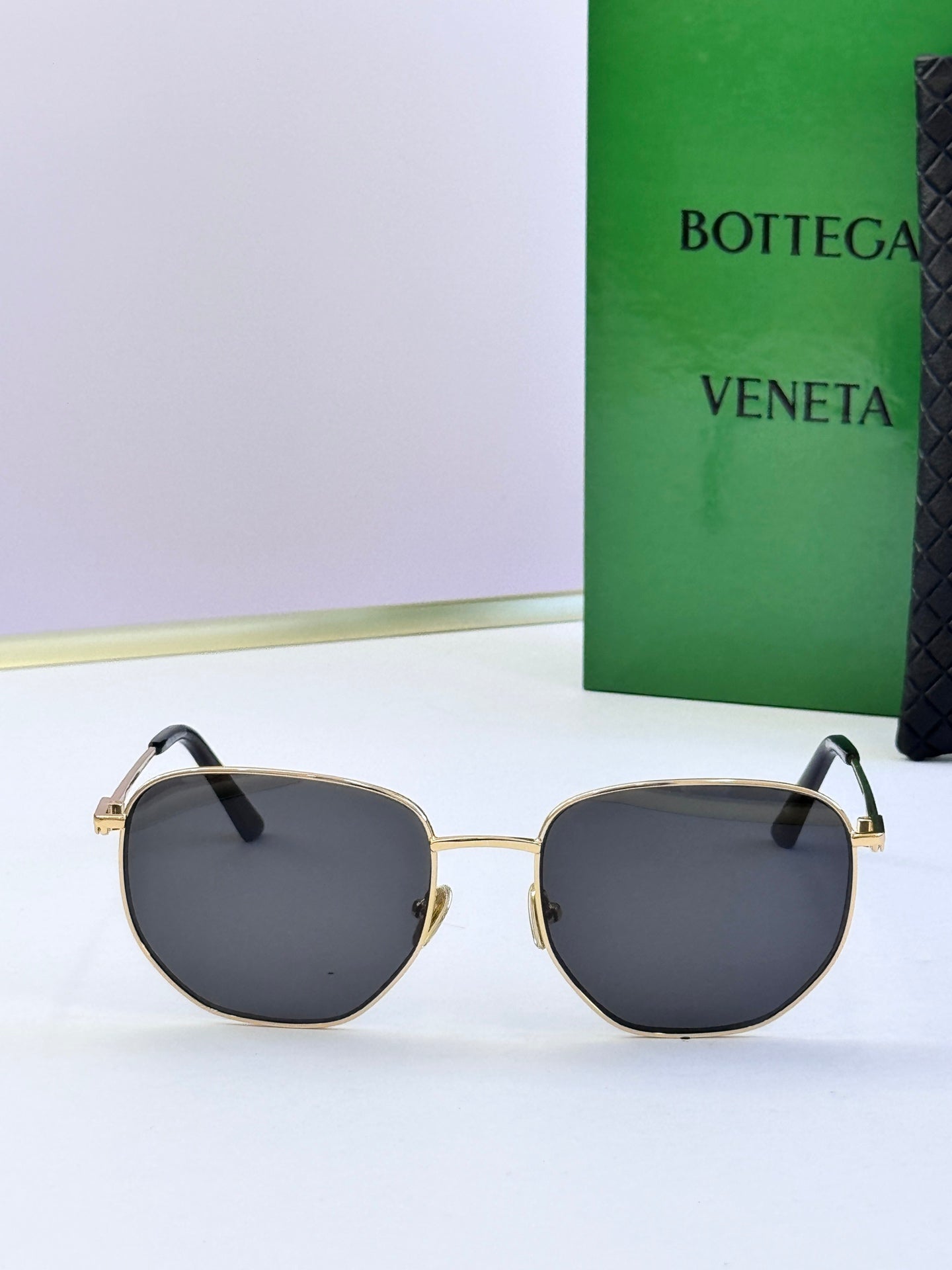 Gold-frame sunglasses with dark gray lenses and black temples