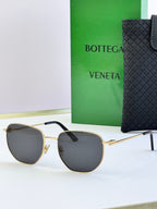 Gold-frame sunglasses with dark gray lenses and black temple tips