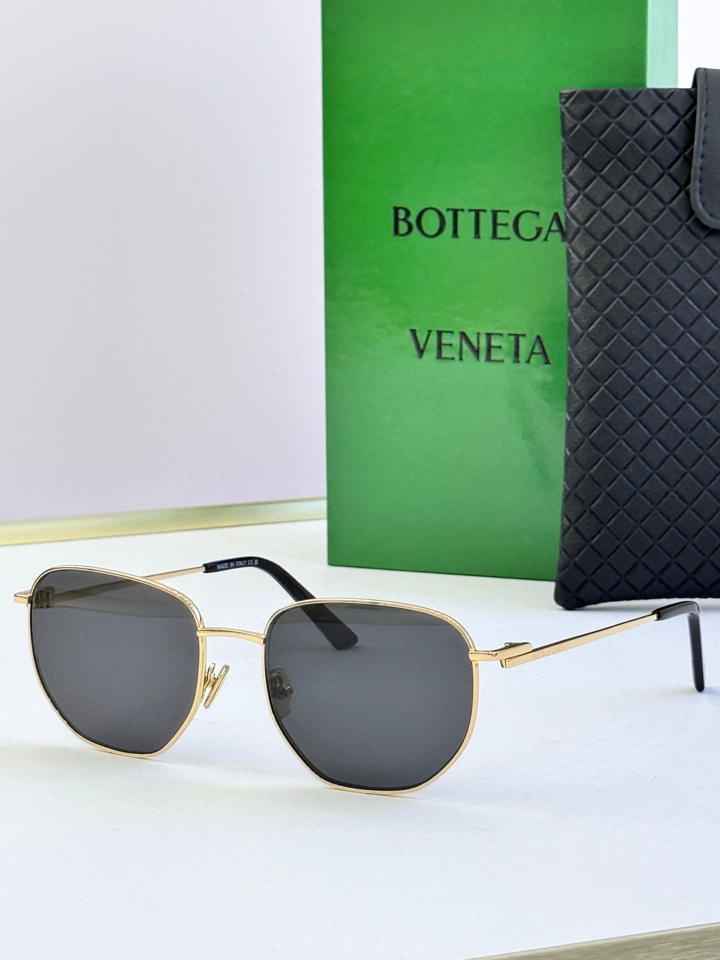 Gold-frame sunglasses with dark gray lenses and black temple tips