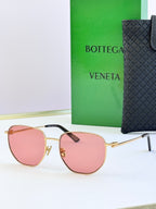 Gold-frame sunglasses with pink lenses and black temple detail