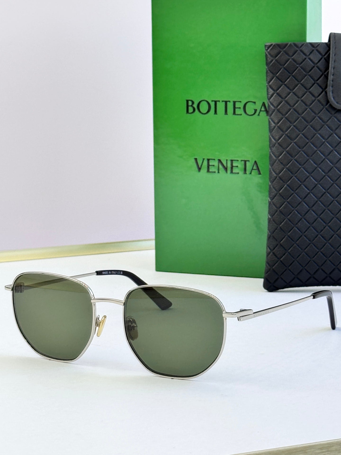 Gold-frame sunglasses with olive-green lenses and black temple tips