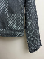 Dark denim jacket sleeve and hem with monogram print and stitched check pattern.
